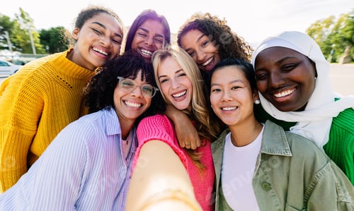 Preview: Multiracial group of seven cheerful women having fun taking selfie portrait