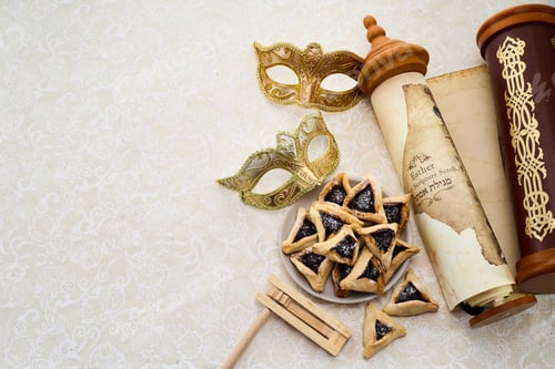 Preview: Purim Celebrations. Golden mask, scroll, gragger, and hamantaschen on decorative background
