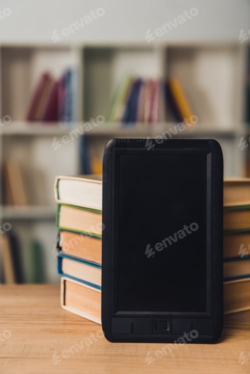 Preview: ebook with blank screen near paper books on table