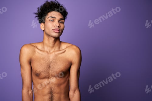 Preview: Portrait of latin american transgender model on purple background. Handsome young man posing camera