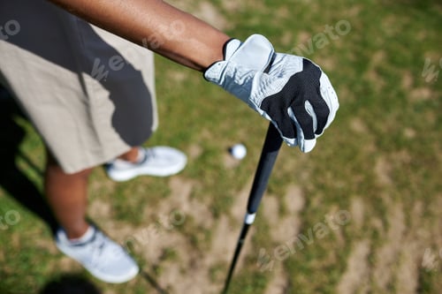 Preview: Top view closeup of gloved female hand holding golf club against grass