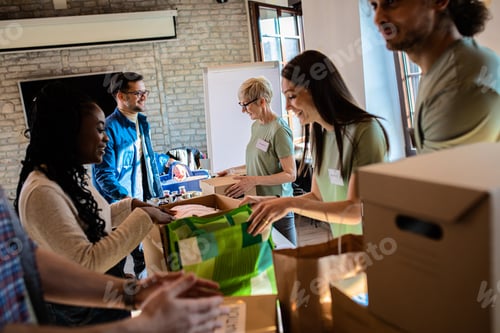 Preview: Group of volunteers with face mask working in community charity donation center.