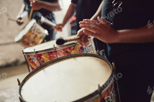 Preview: Closeup shot of a musical performer playing drums with his band