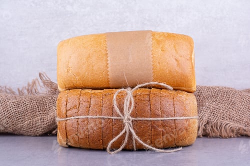 Preview: Whole and sliced blocks of bread on marble background