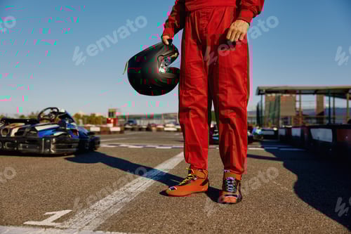 Preview: Cropped closeup shot of go-kart driver holding helmet in hands