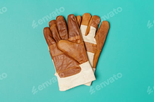 Preview: Work gloves placed on a blue surface for a tool kit or work project