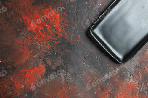 Preview: top half view black rectangular plate on dark red background copy space