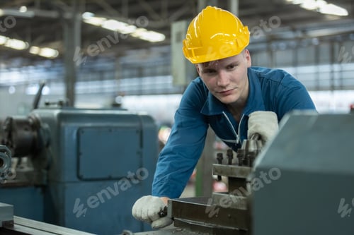 Preview: Caucasian man engineering workers wear yellow hard hat working machine lathe metal in factory.