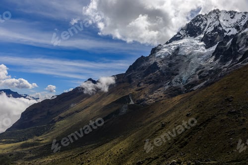 Preview: Stunning view of the snow-capped Salkantay Mountain peak with clouds against a clear blue sky.