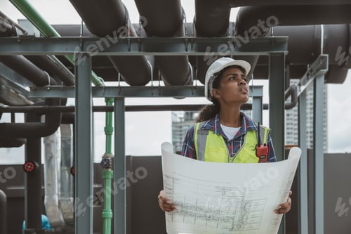 Preview: Engineers with draft plan of building on constructing site. Engineer working on building site