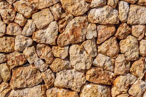 Preview: Weathered stone wall covered with an intricate mosaic of variously-sized rocks.