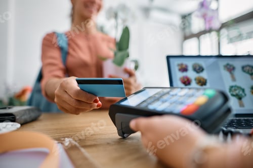 Preview: Close up of flower shop customer paying with her credit card.