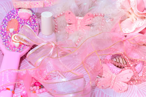 Preview: Girls fashion accessories in pink hues. Pink ribbons, hair brush and nail polish all in pink color.