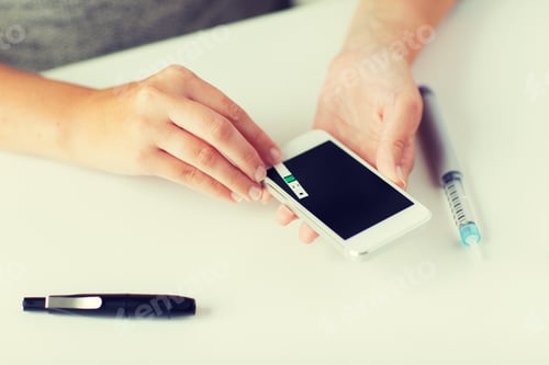 Preview: close up of woman with smartphone doing blood test
