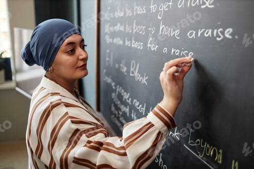 Preview: Muslim Woman Writing Sentences on Chalkboard Studying English in Classroom