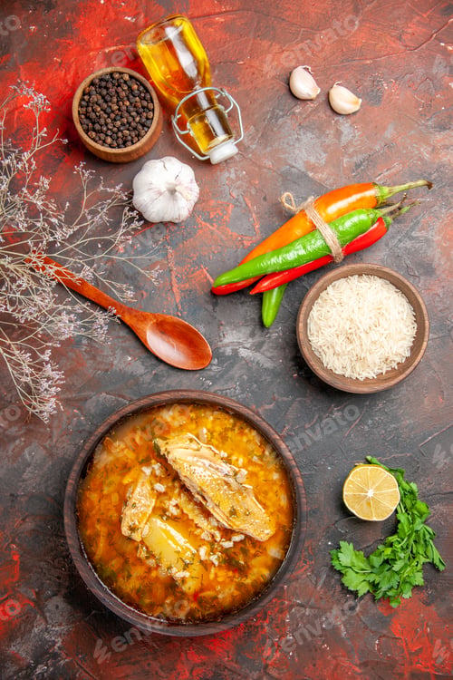 Preview: top view bowl of chicken soup wood spoon hot peppers bottle of oil bowl of black pepper rice slice