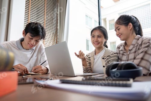 Preview: Group of Happy Students Studying Together with Laptop and Books in a Bright Modern Classroom