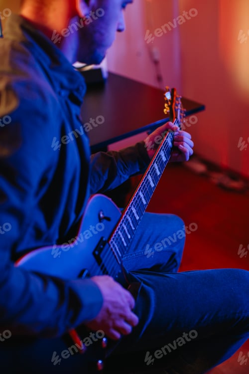Preview: Musician composing music at home playing electric guitar