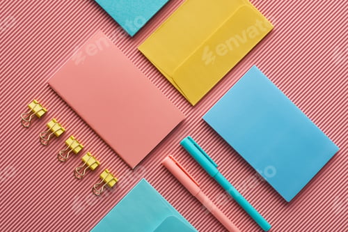 Preview: background with colorful stationery supplies on pink