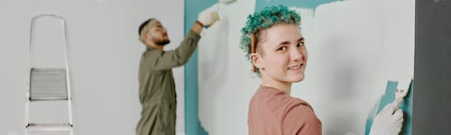 Preview: Header with Couple Painting Accent Wall Together during Apartment Renovation