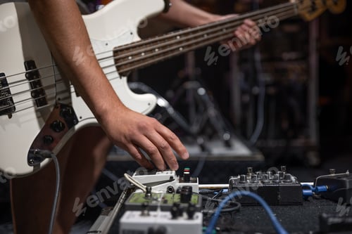 Preview: Guitar player on a stage with set of distortion effect pedals.