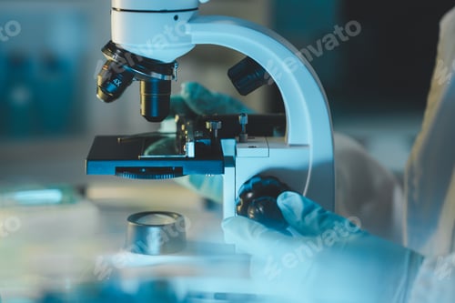 Preview: female medic in uniform working with microscope making analysis at the laboratory, Close-up shot of