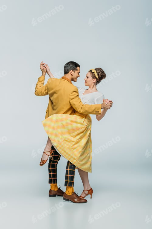 Preview: elegant dancers holding hands while dancing boogie-woogie on grey background