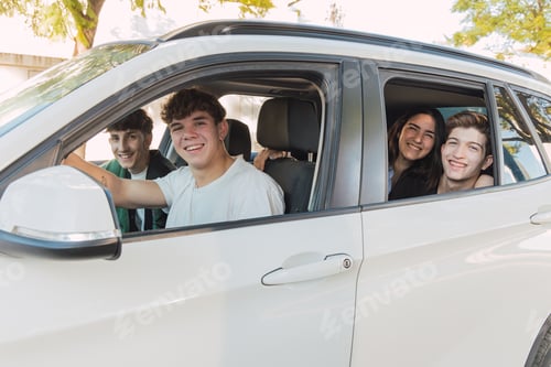 Preview: Cheerful friends sitting in parked white car in daylight near building