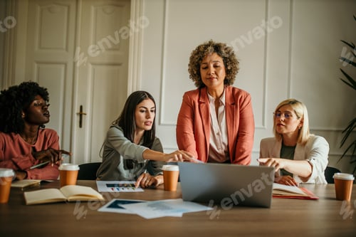 Preview: Businesswomen working together on laptop in office meeting room