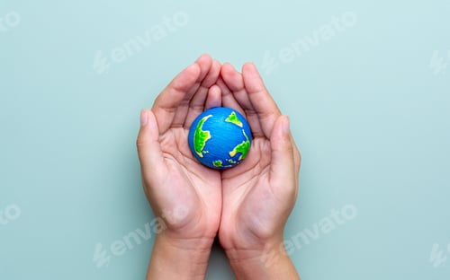 Preview: A hands holding a small Earth model.