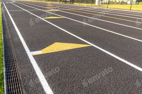 Preview: Inspiring close up of the end of an exchange zone on a new black running track with white lane lines