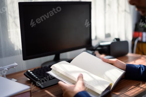 Preview: businessman reading and writing book at work