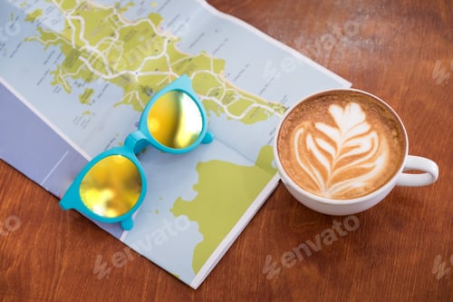 Preview: White coffee cup with latte art with travel map and sunglasses on brown wood table,Leisure activity