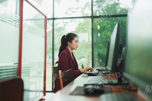 Preview: Young asian woman working on computer in modern office