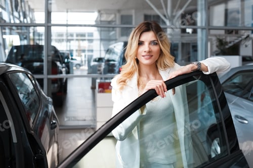 Preview: Elegant business woman leans on the door of her new car