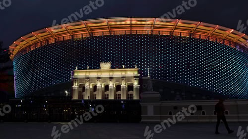 Preview: A huge illuminated stadium at night. Stock footage.A tall large stadium fenced with a fence