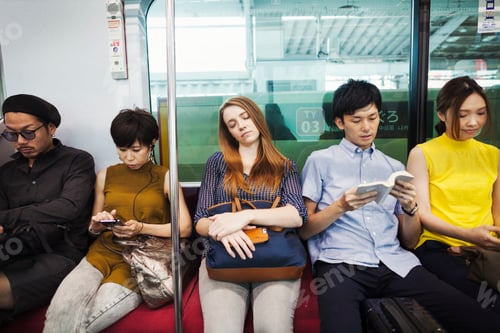 Preview: Five people sitting sidy by side on a subway train, Tokyo commuters.