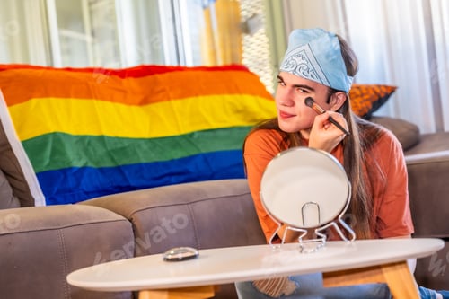 Preview: Transgender man making up using brush and mirror at home