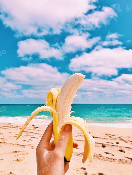 Banana Held on Beach During Sunny Day