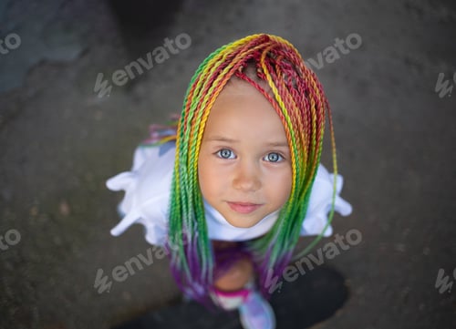 Preview: portrait of a little beautiful girl with multi-colored african braids