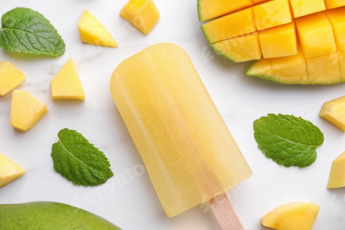 Preview: Tasty mango ice pop on white marble table, flat lay. Fruit popsicle