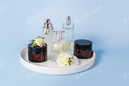 Preview: Set of natural organic facial skin care products in jars and perfume on tray and blue background.
