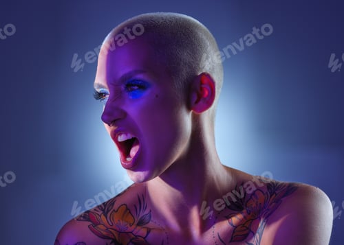 Preview: Studio shot of an attractive young woman wearing edgy makeup against a blue background