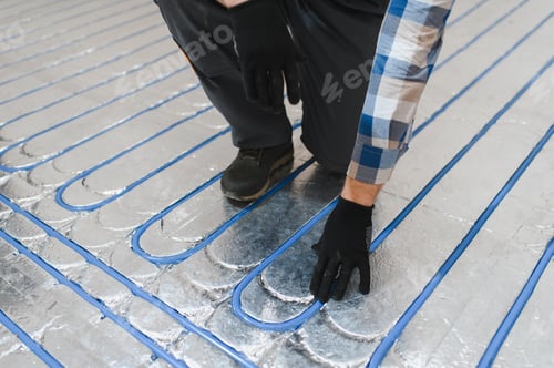 Preview: Service man instelling house heating system under the floor