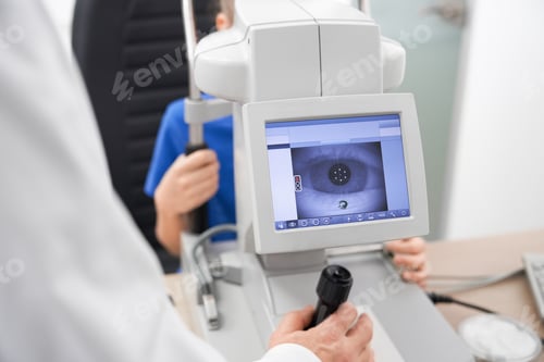 Preview: Clever male oculist using machine for checking eye sight