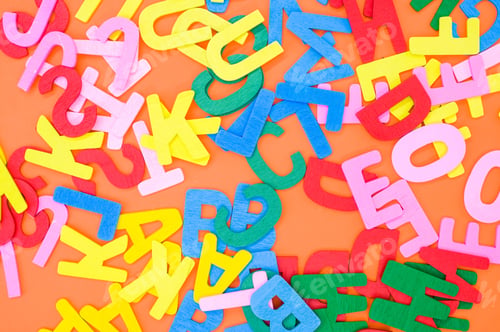 Preview: Top view closeup of the letters of the English alphabet isolated on an orange background