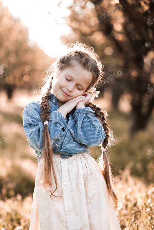 Preview: Happy child girl with closed eyes wear stylish cloth in meadow at sunny nature background.