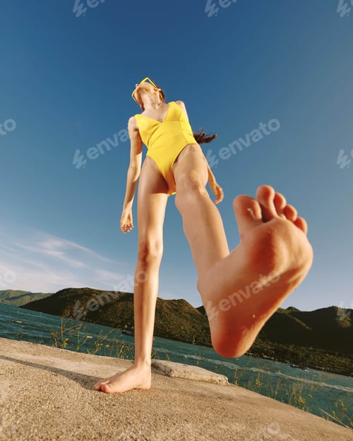 Preview: Yellow swimsuit woman doing a handstand on a concrete wall against a clear blue sky, showcasing