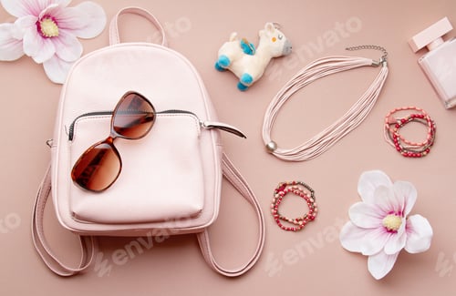 Preview: Flat lay with pink woman accessories with backpack and woman hand holding the sunglasses. Summer