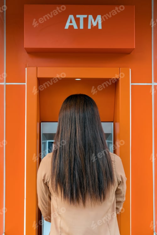 Preview: Back side of woman withdrawing the cash via ATM, business Automatic Teller Machine concept